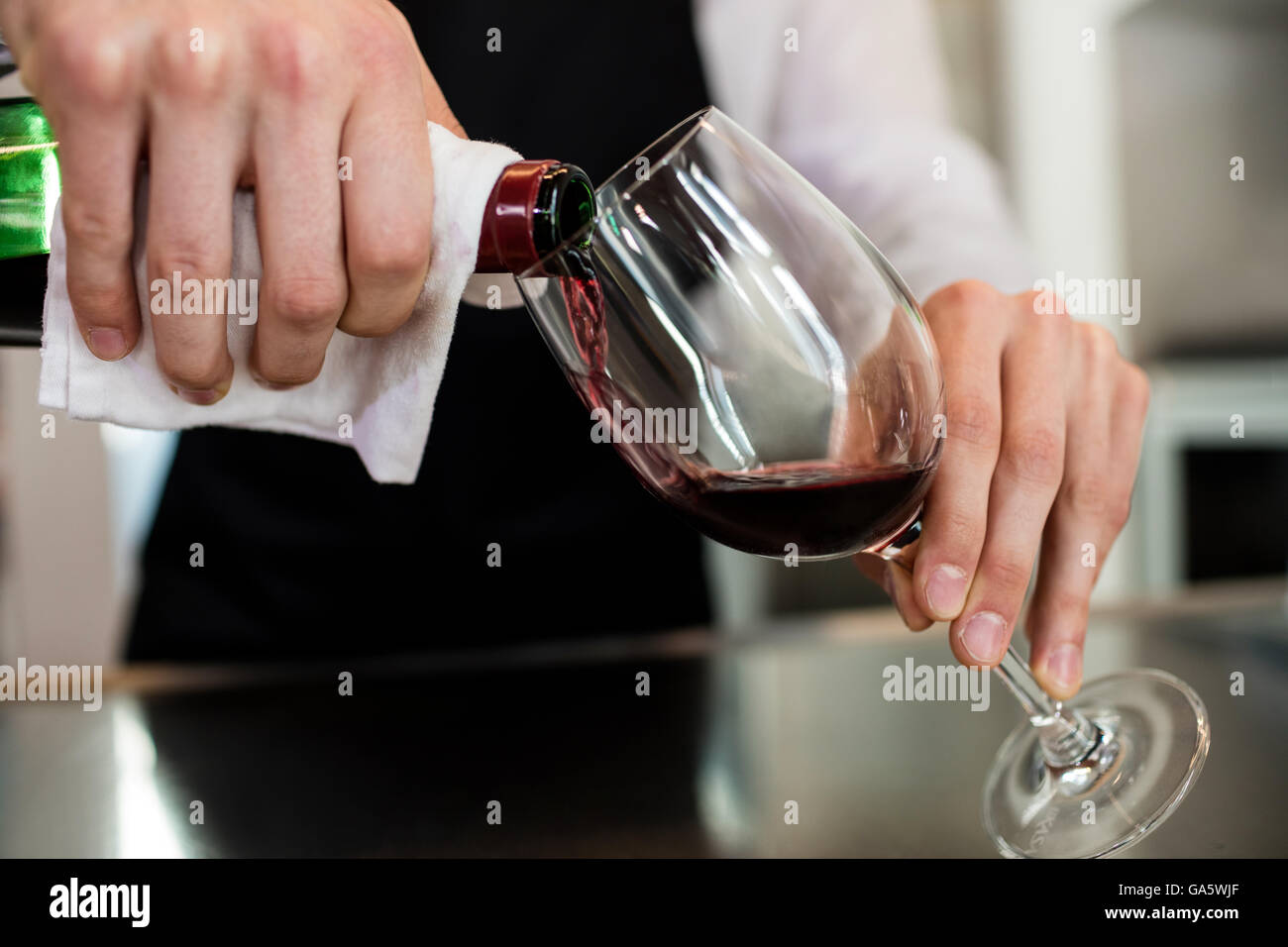 Barkeeper pouring wine in glass Stock Photo