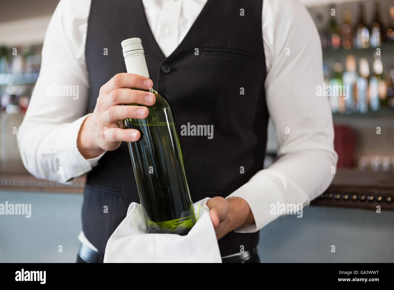 Waiter holding a bottle of wine Stock Photo Alamy