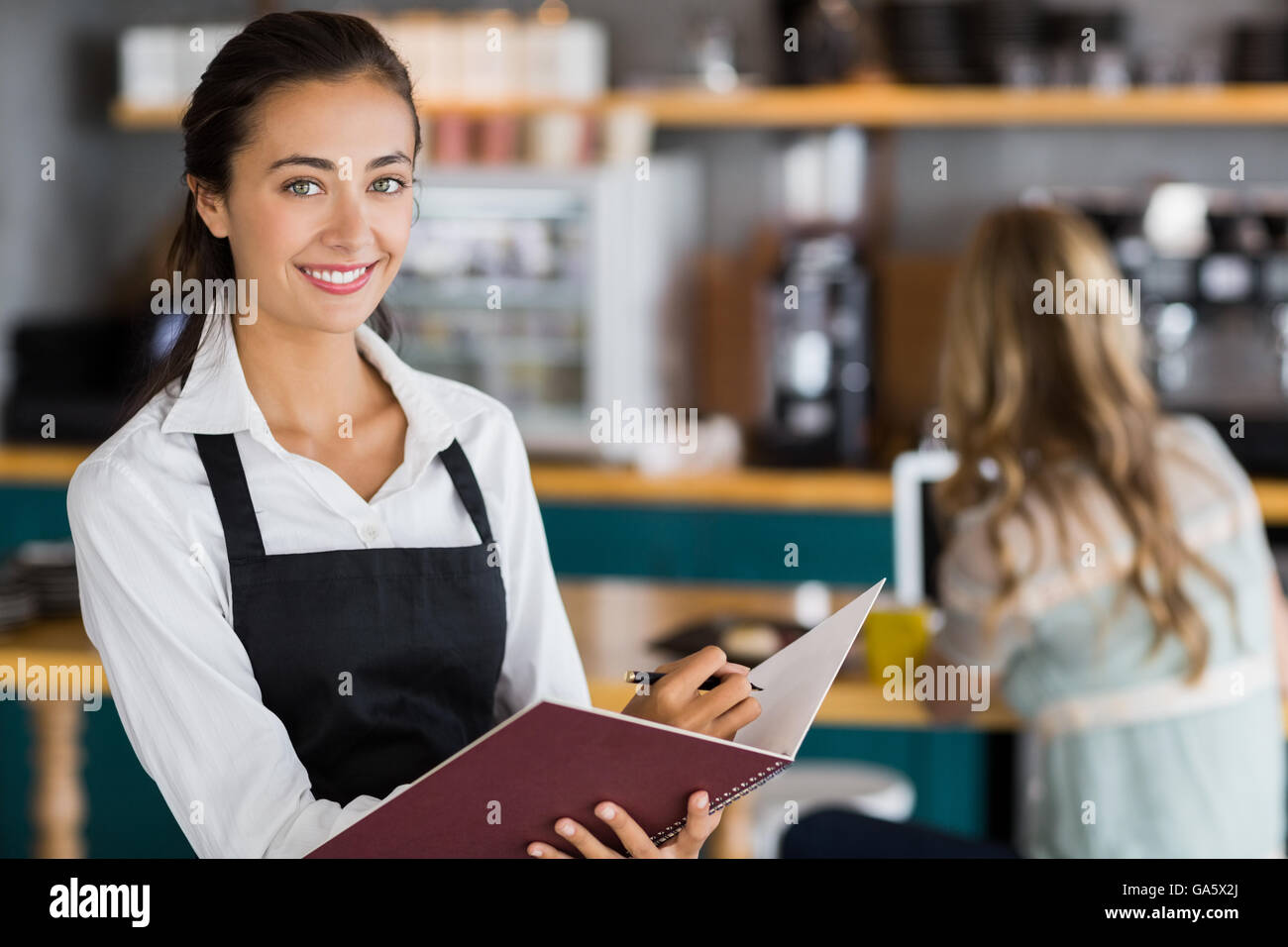 Script Being Waitress Portrait of smiling waitress writing in a file Stock Photo - Alamy