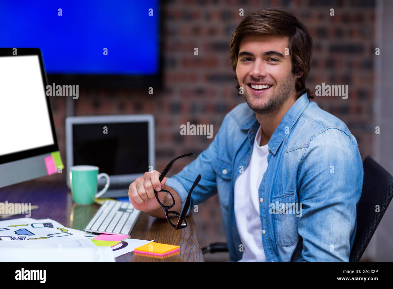 Young businessman sitting at desk Stock Photo