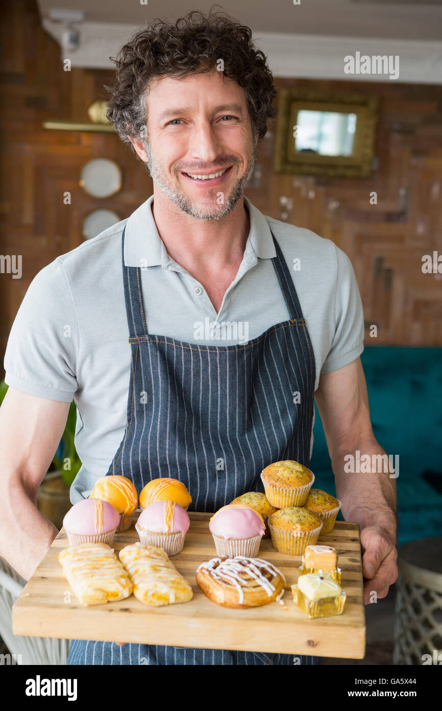 Waiter holding wooden tray with dessert Stock Photo