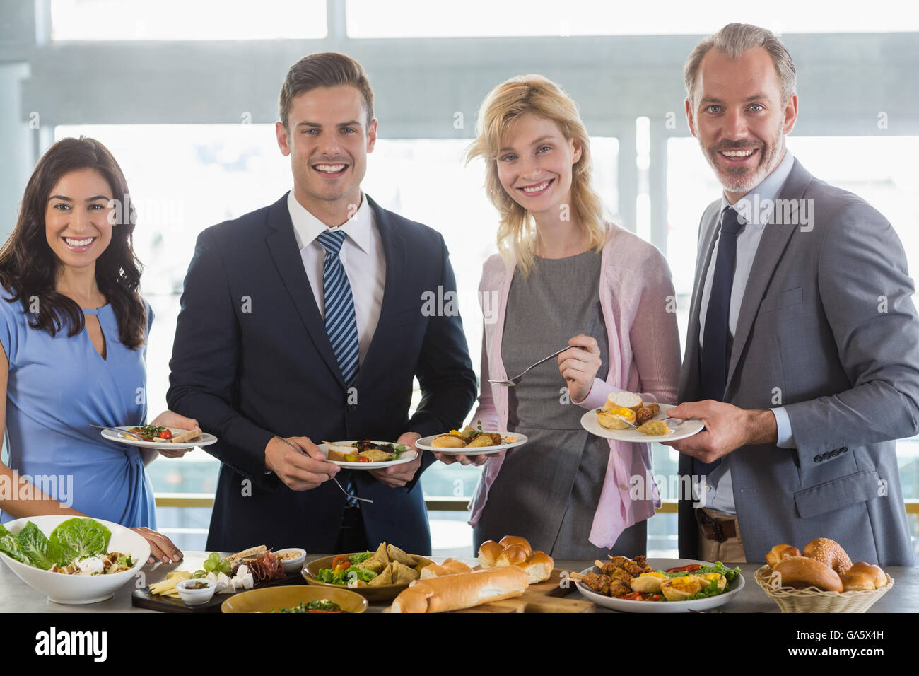 Portrait of business colleagues serving themselves at buffet lunch Stock Photo