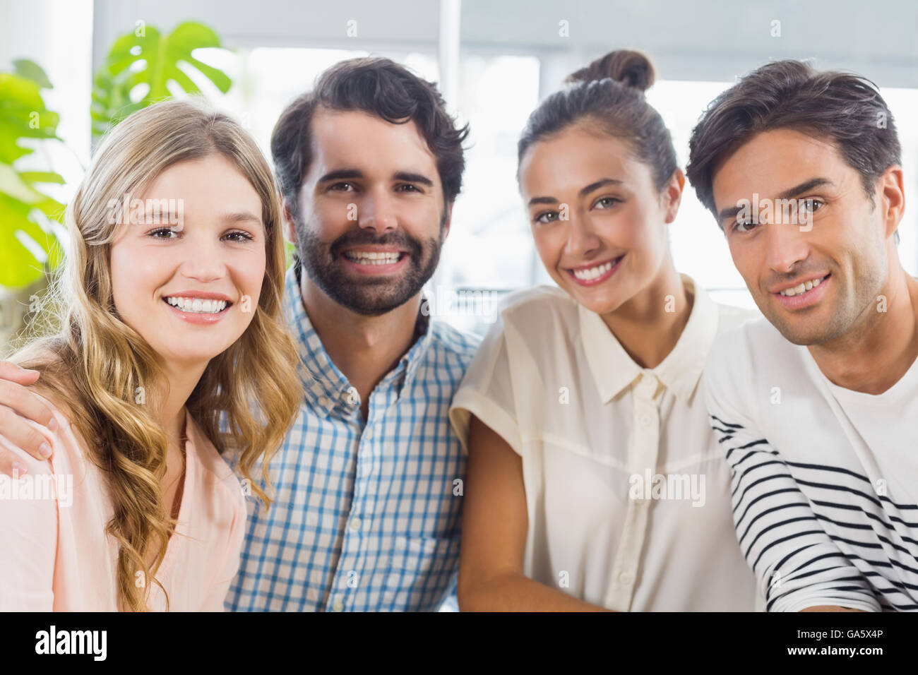 Portrait of smiling friends sitting together Stock Photo