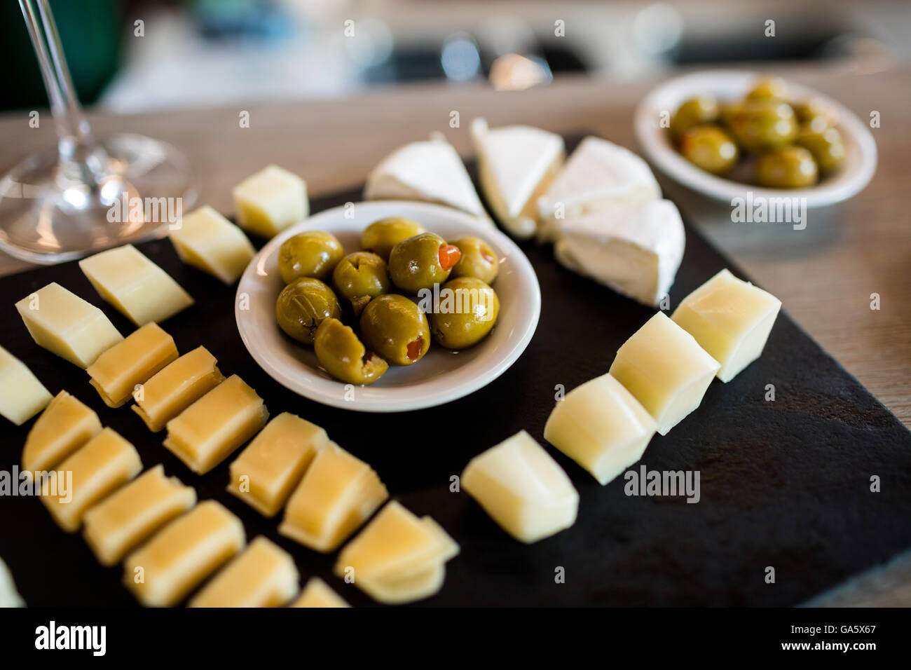 Cheese slices and olives on tray Stock Photo