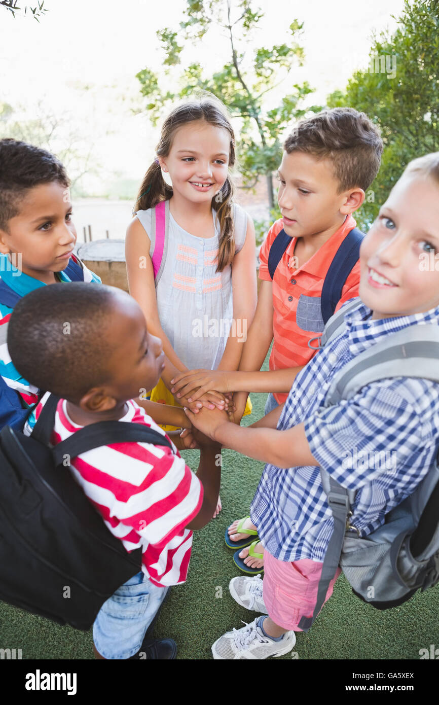 Schoolkids putting their hands together in campus Stock Photo