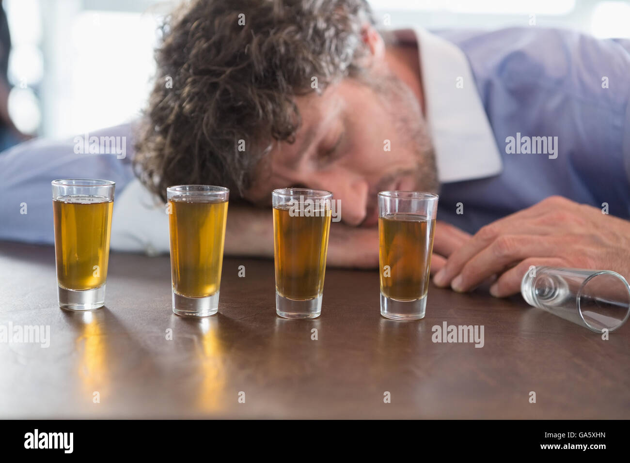 Drunken man sleeping on a bar counter Stock Photo Alamy