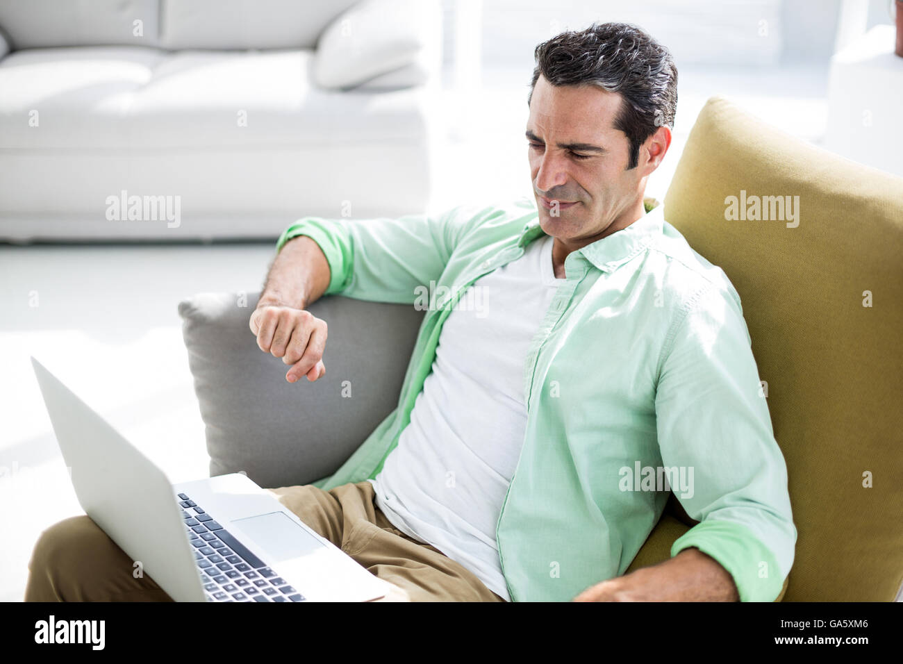Man using laptop while siting on couch Stock Photo