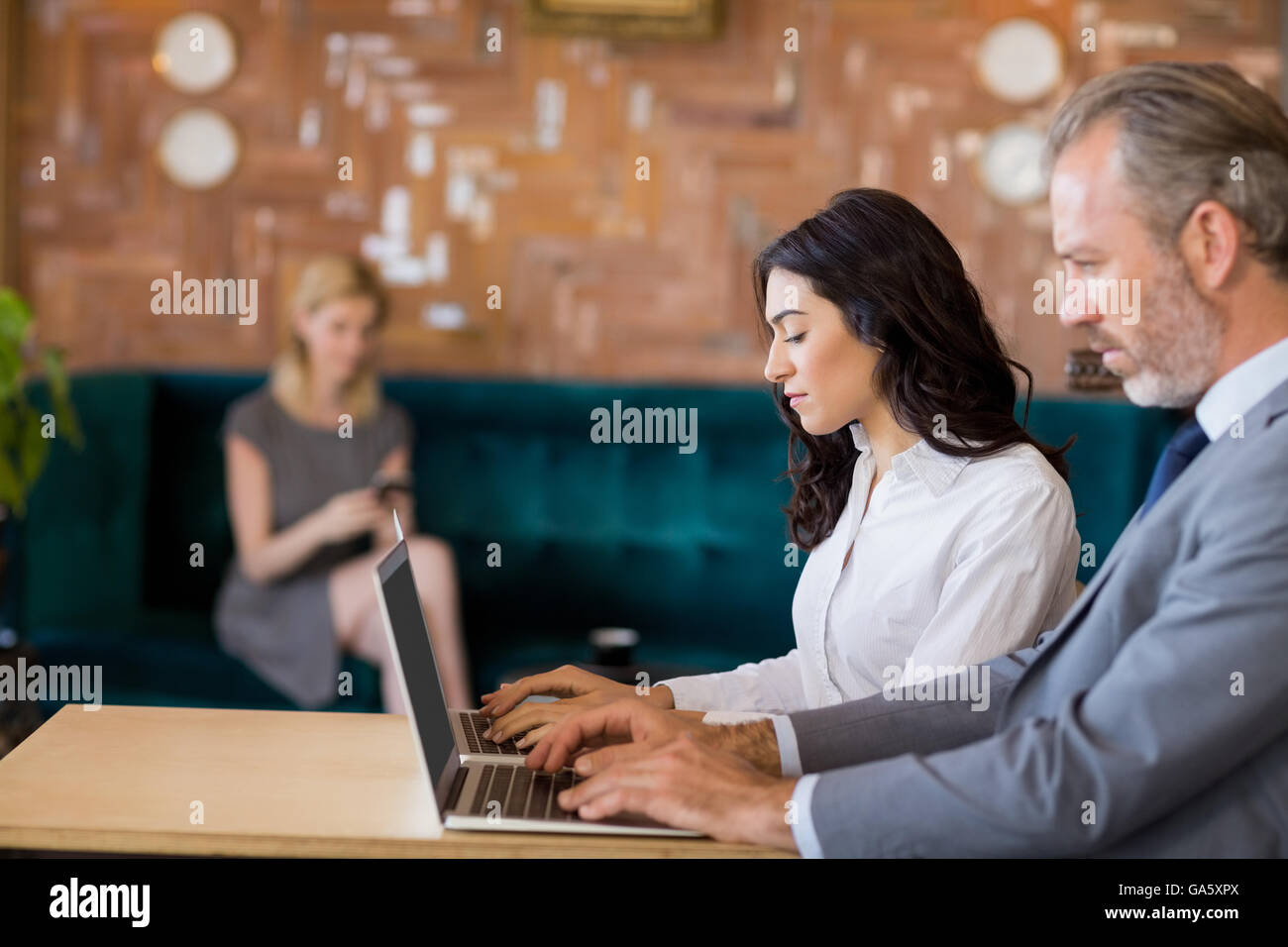 Business colleagues sitting on table and using laptop Stock Photo