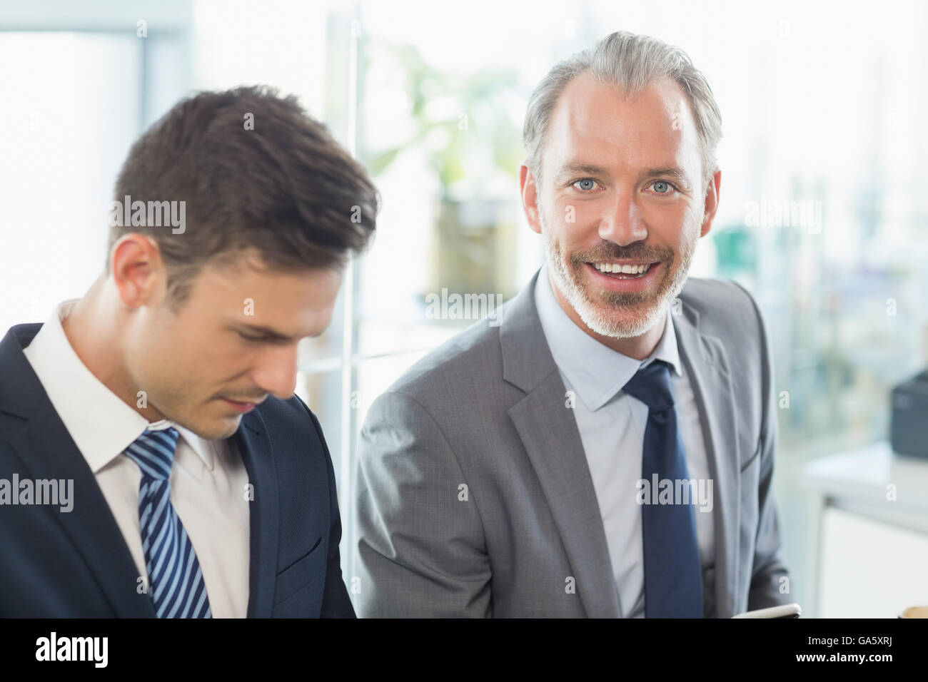 Two businessmen sitting with each other Stock Photo