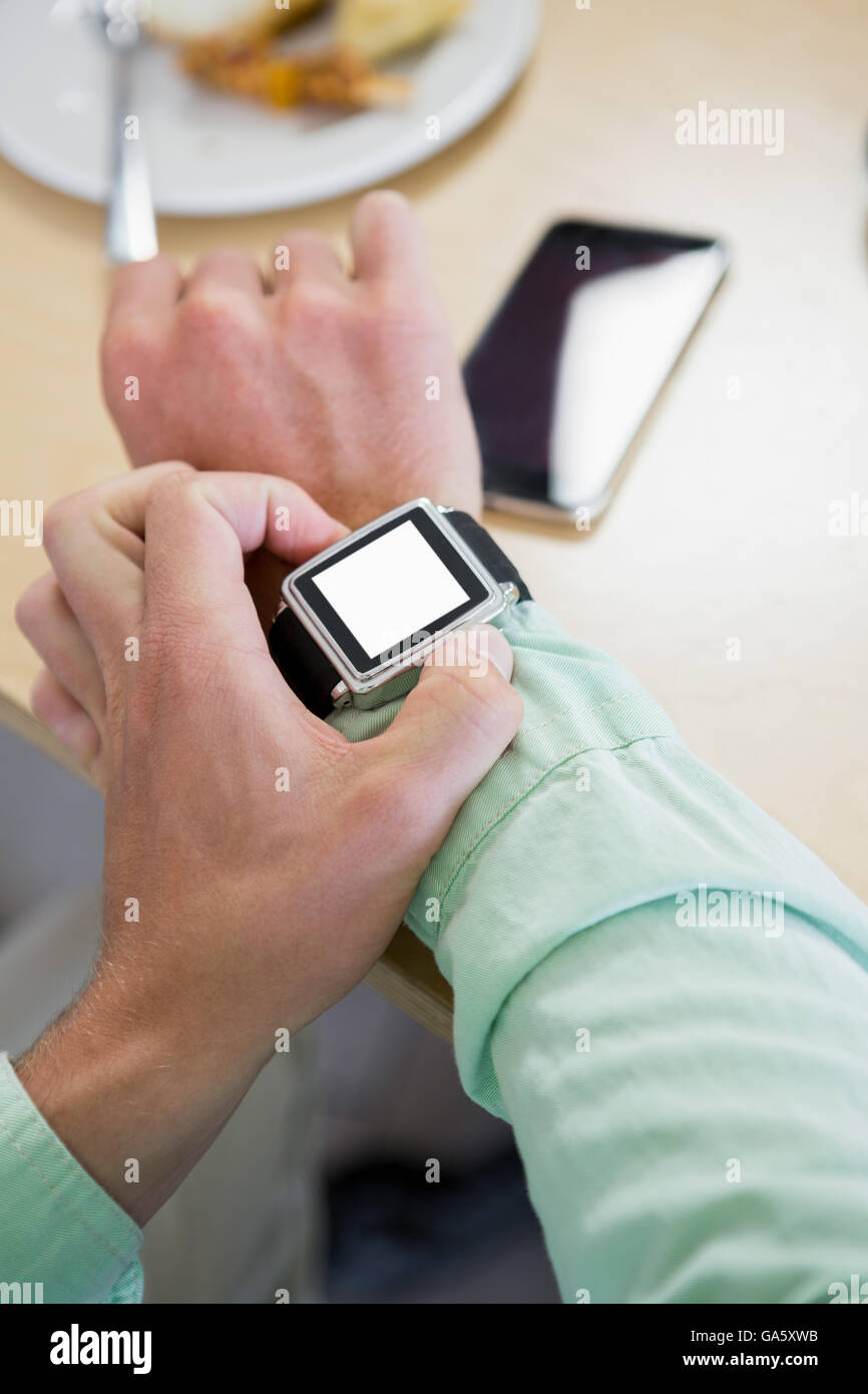 Man adjusting time on his smartwatch Stock Photo