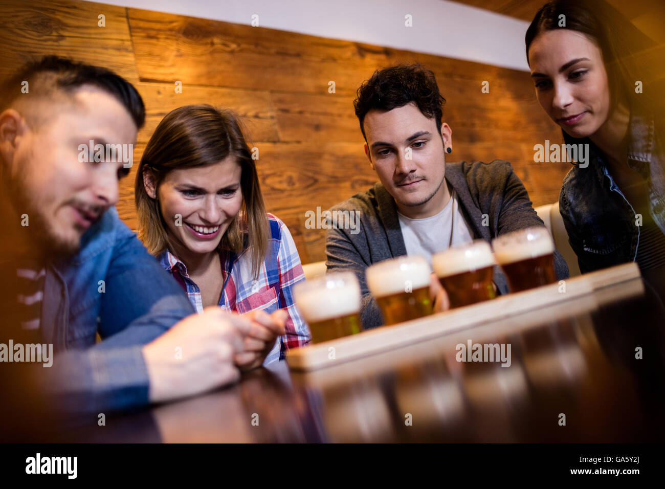Friends looking at beer glasses in restaurant Stock Photo
