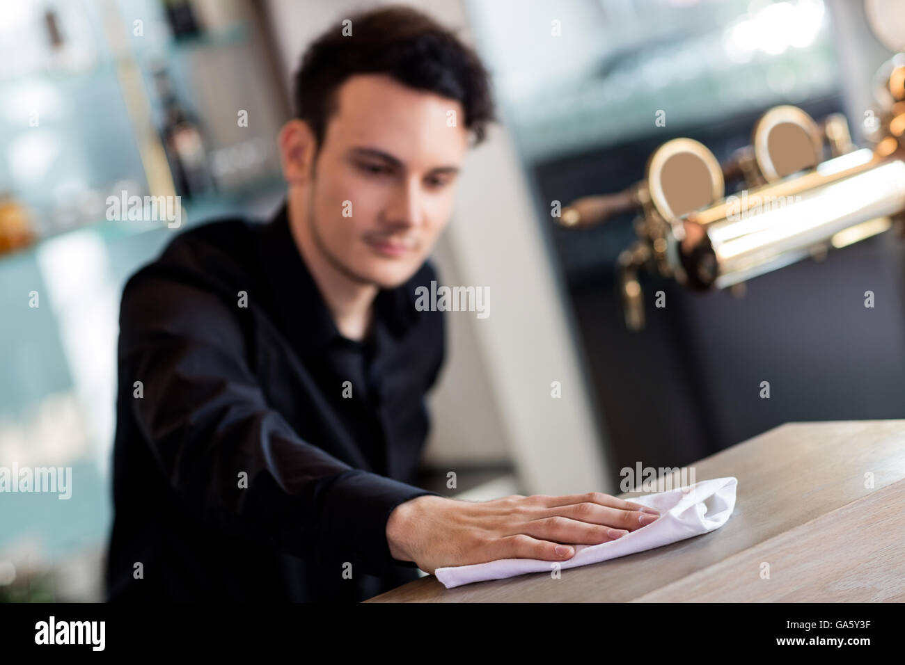 Barkeeper cleaning counter with napkin Stock Photo