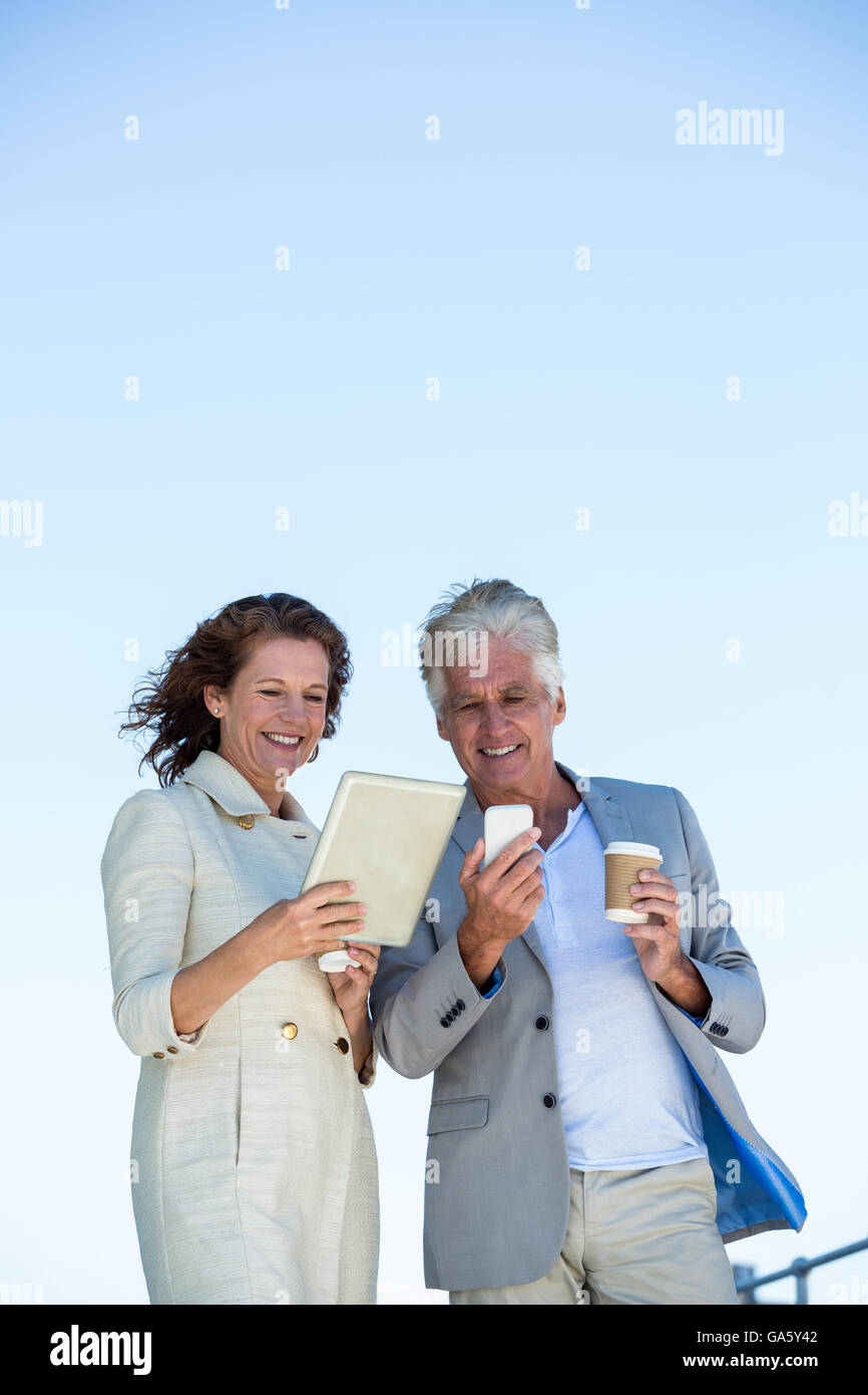 Smiling couple using digital tablet and mobile phon Stock Photo