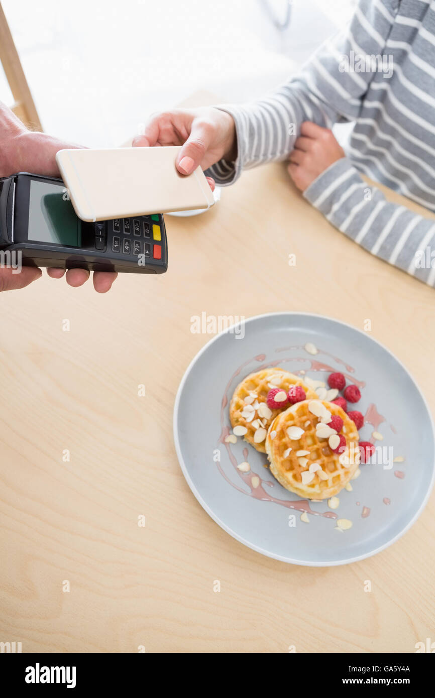 Woman making payment through NFC Stock Photo