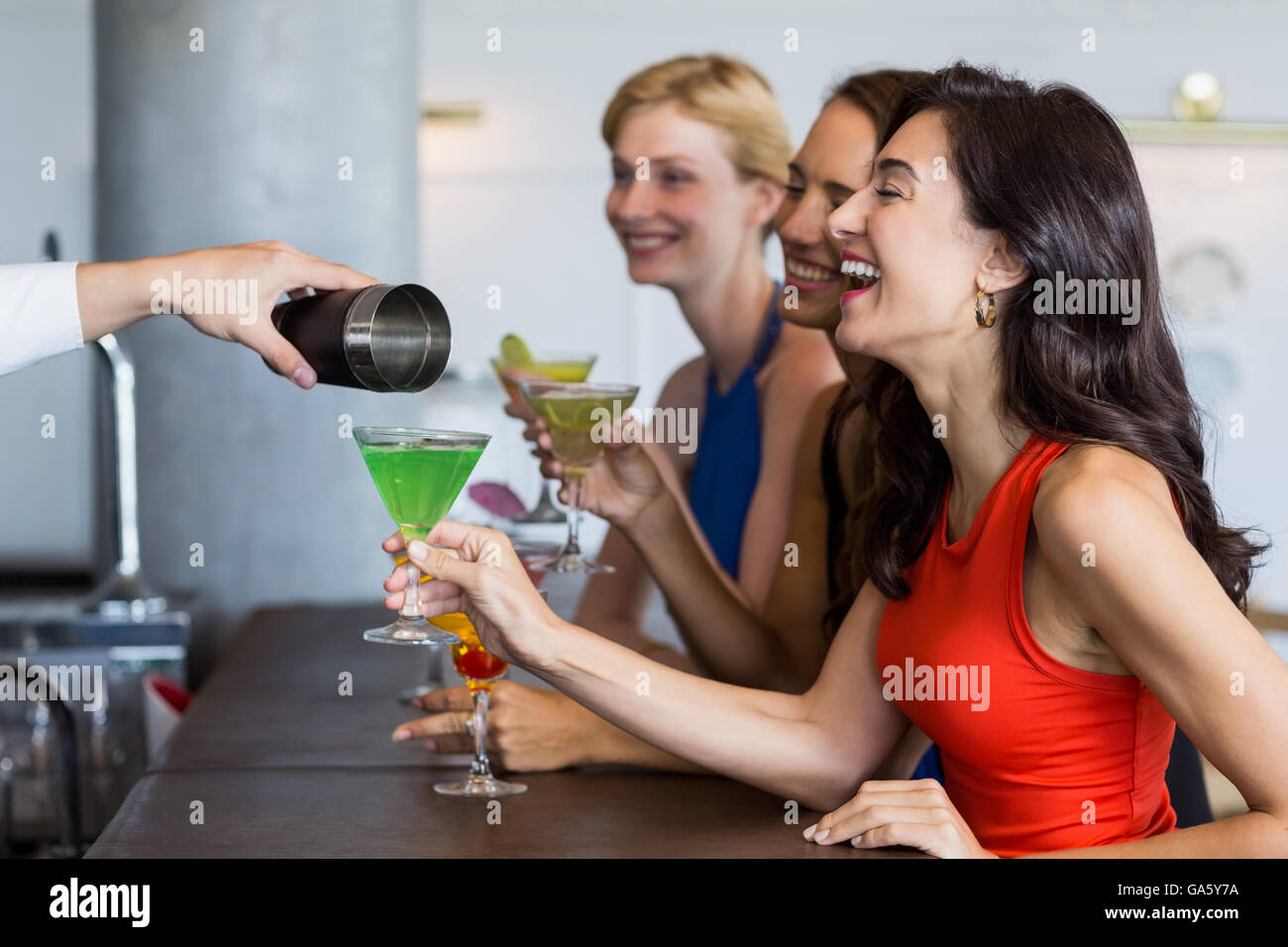 Waiter pouring cocktail into cocktail glass Stock Photo