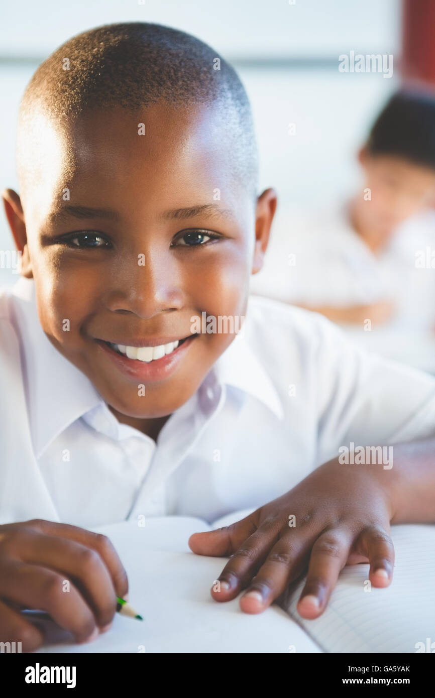 Schoolboy doing homework in classroom Stock Photo