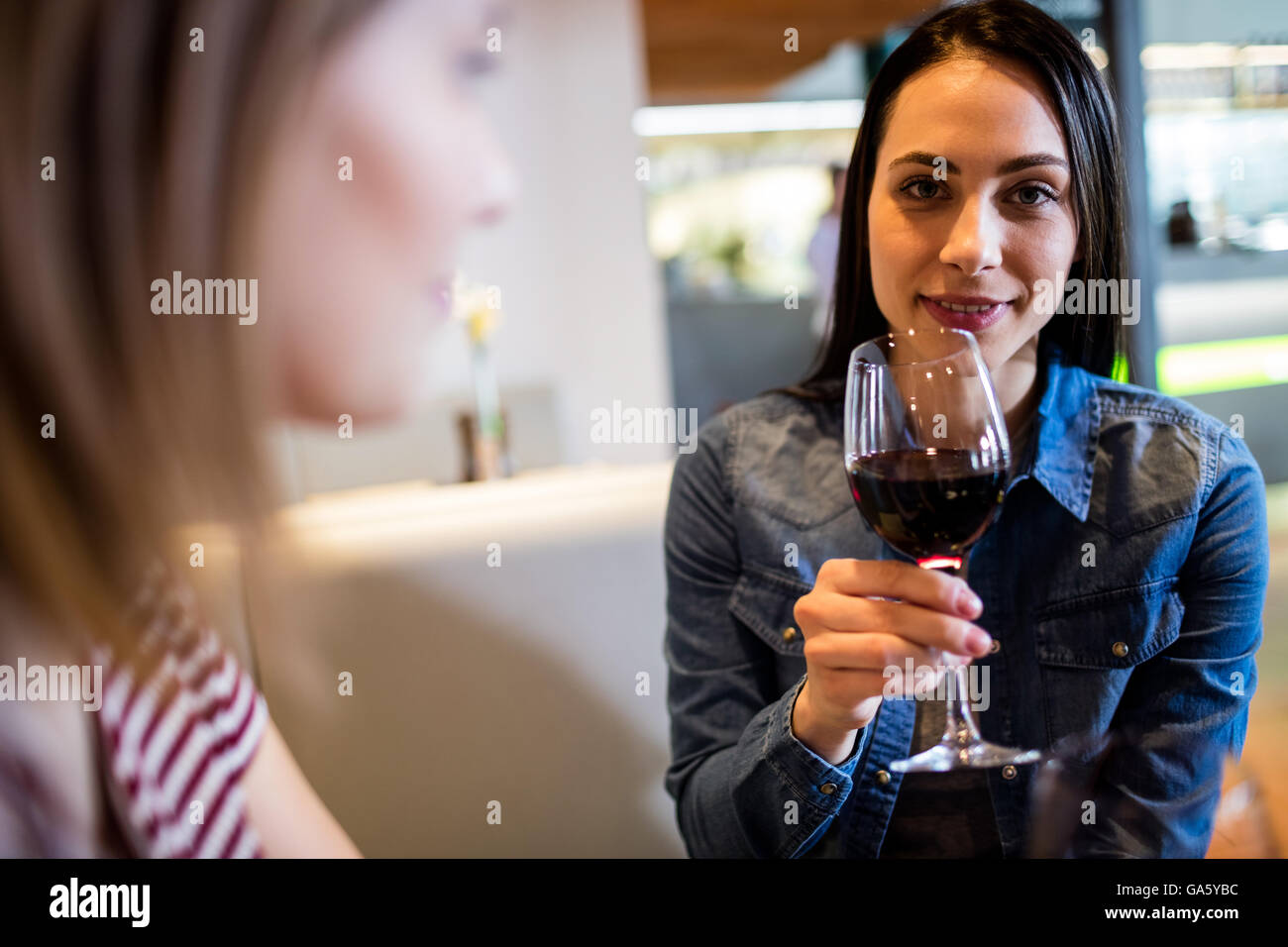 Beautiful woman drinking wine with friend Stock Photo