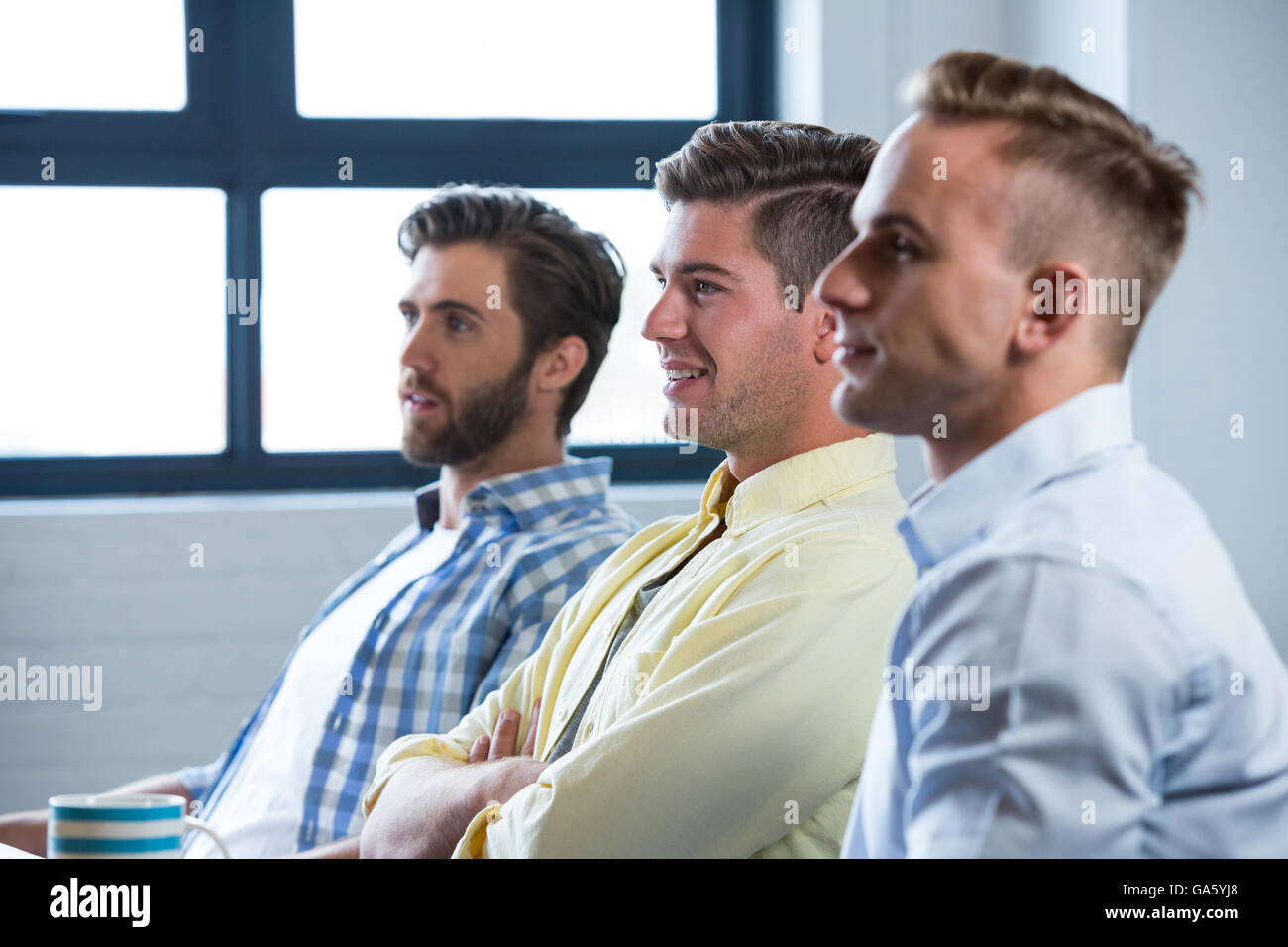 Confident businessmen sitting in creative office Stock Photo