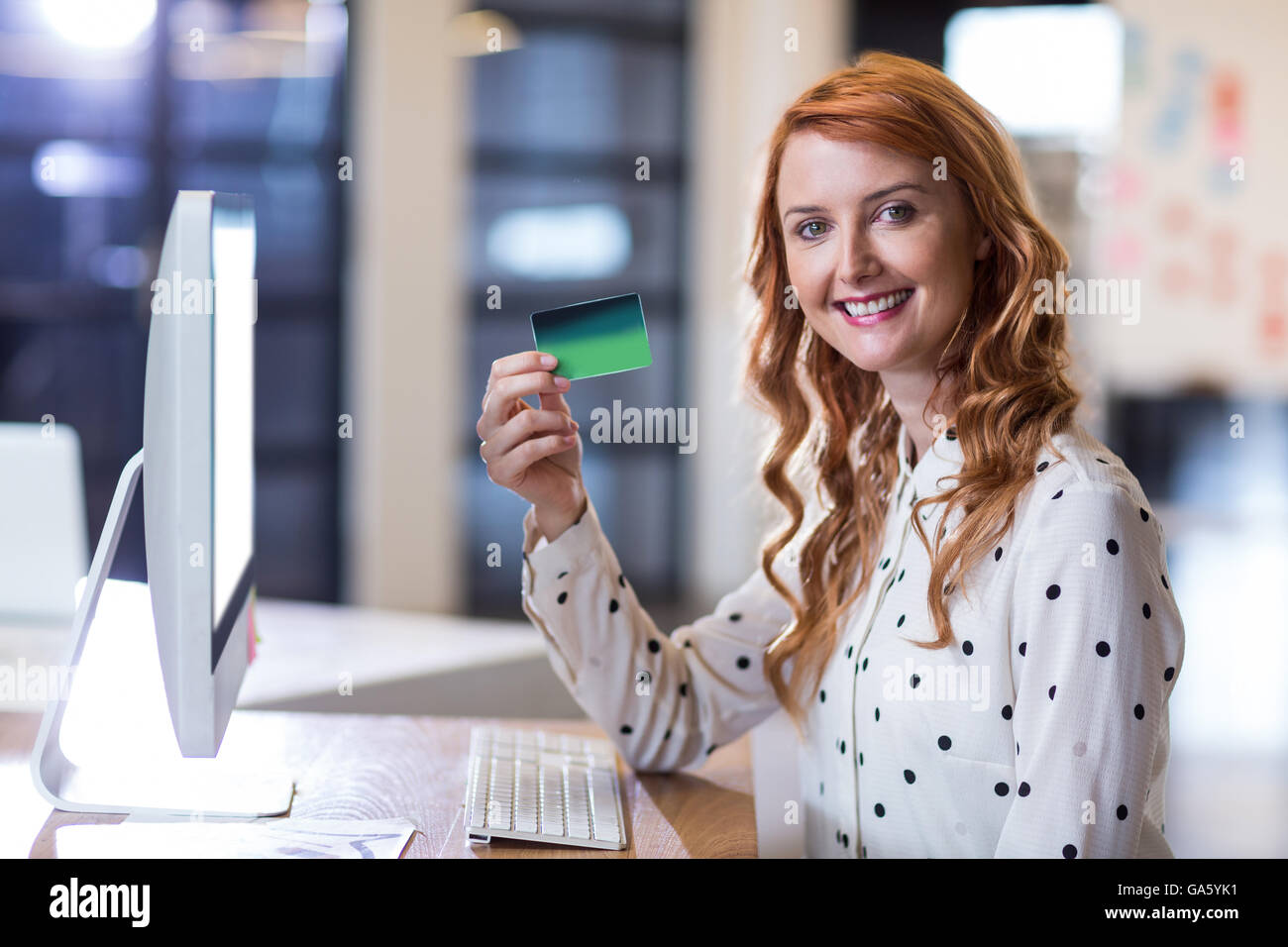 Businesswoman holding smart card in office Stock Photo