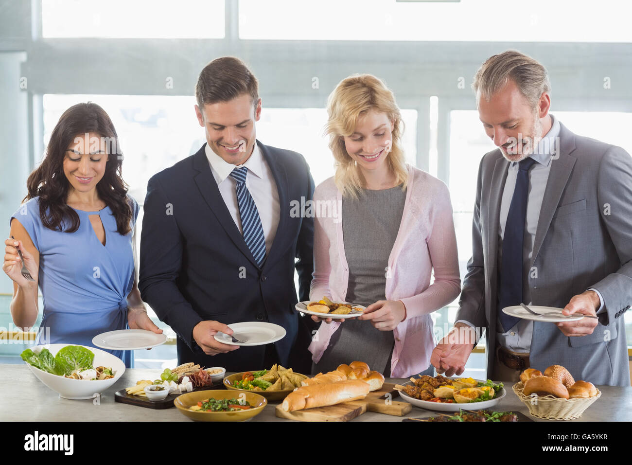 Business colleagues serving themselves at buffet lunch Stock Photo