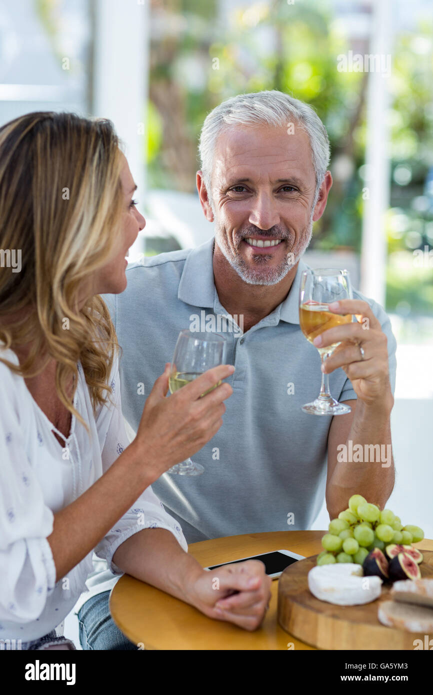 Man holding wineglass while sitting by woman Stock Photo