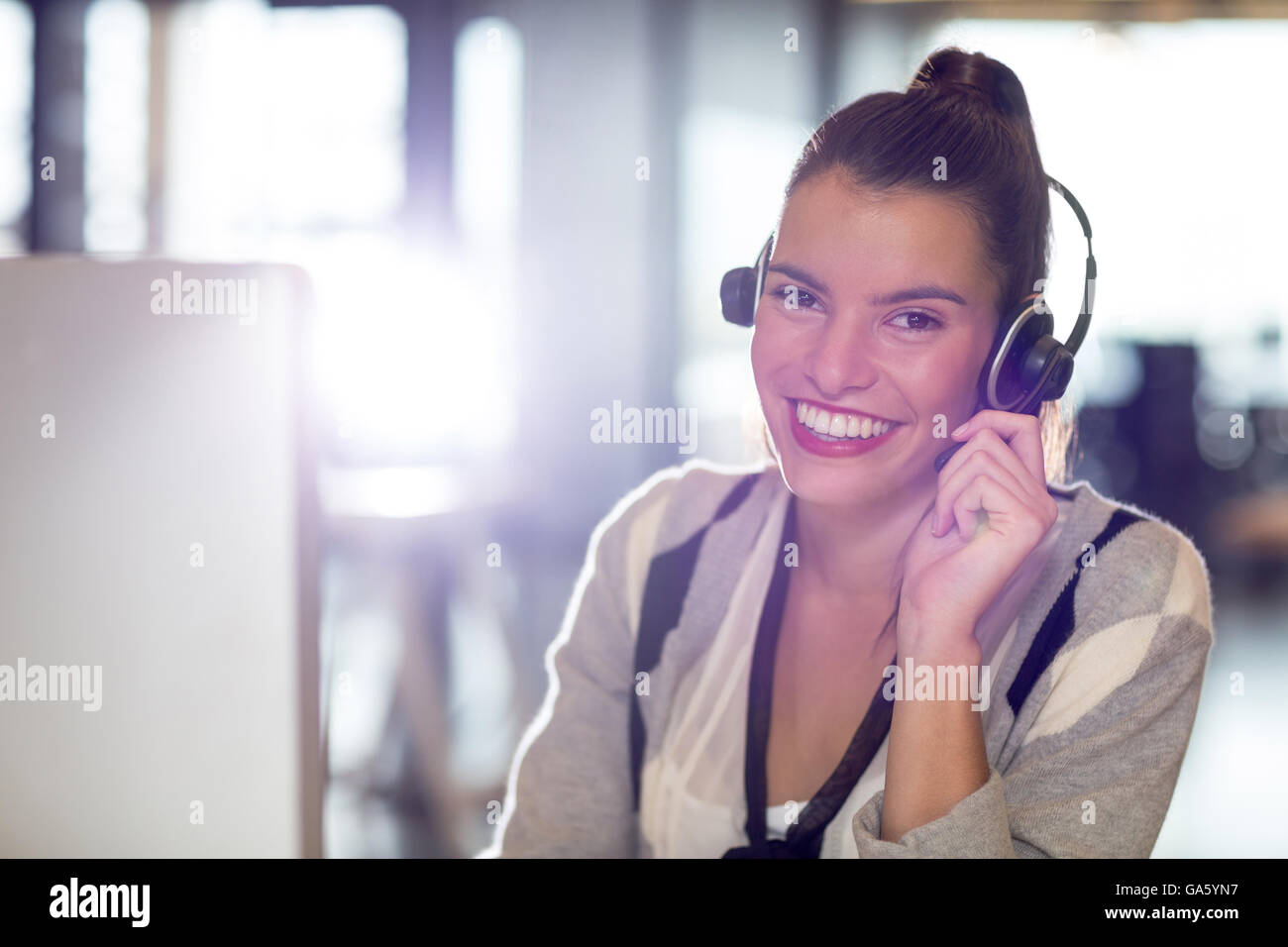 Portrait of woman with headphones in office Stock Photo