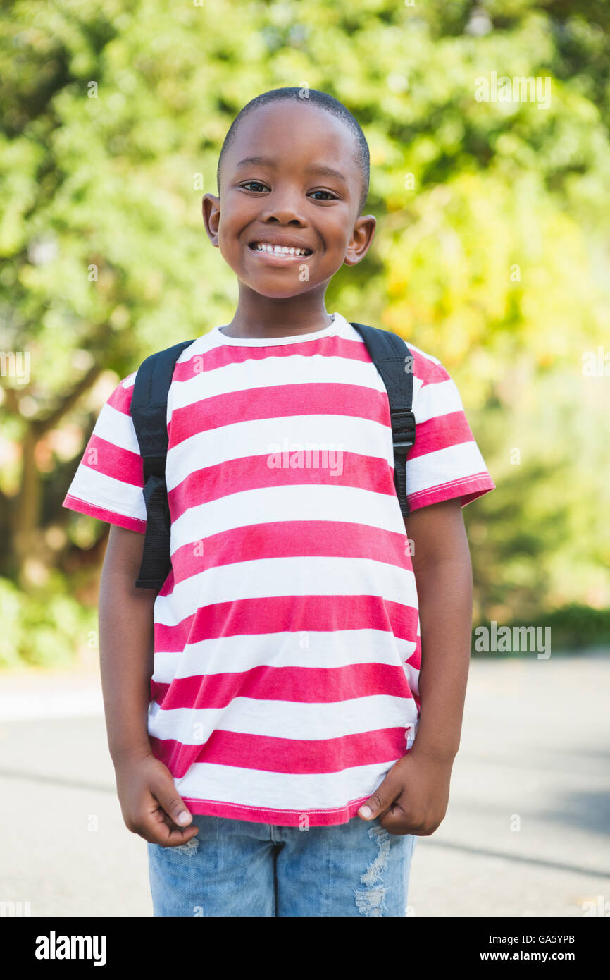 Happy schoolboy standing in campus Stock Photo