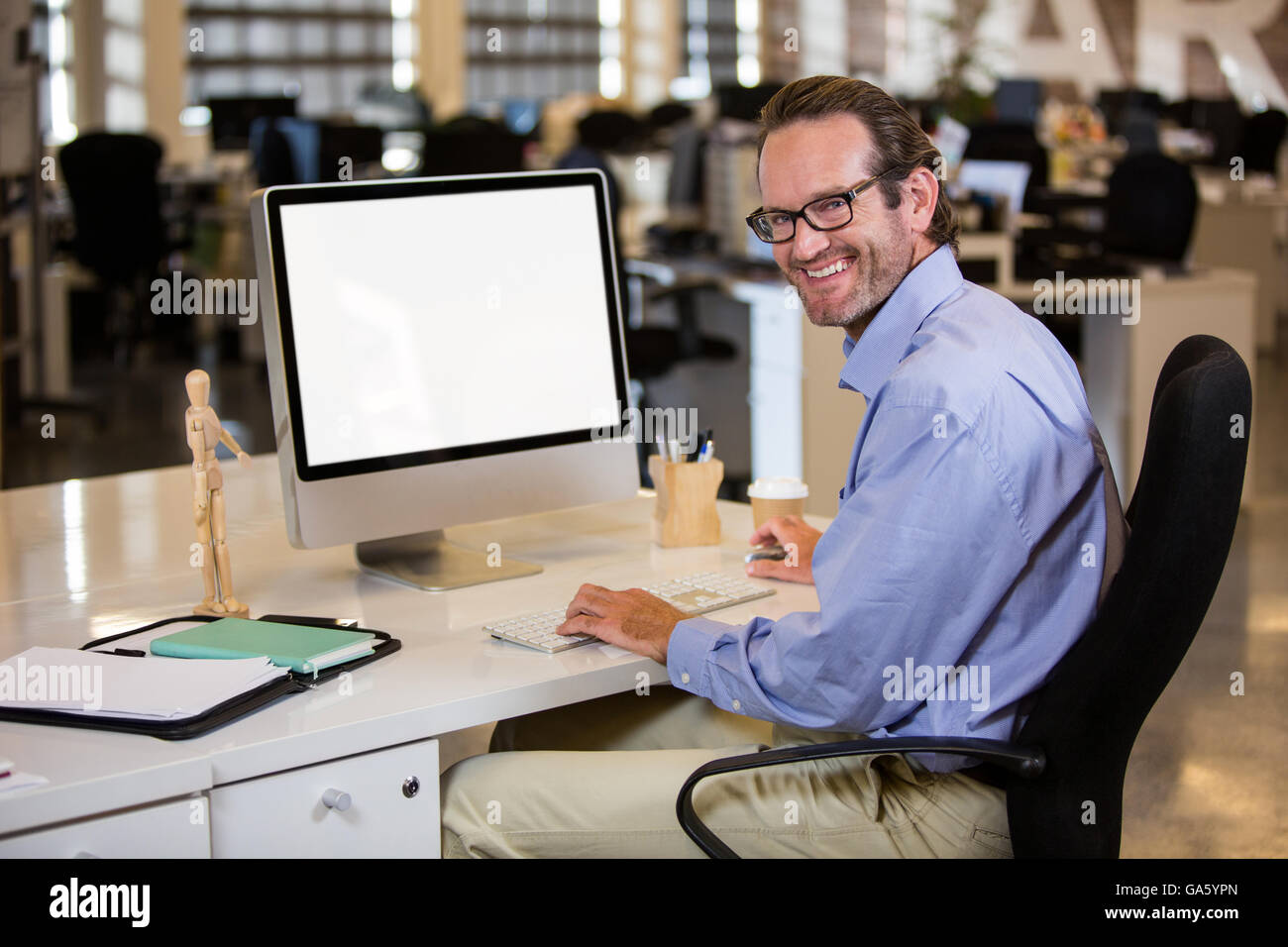 Businessman sitting at computer desk Stock Photo
