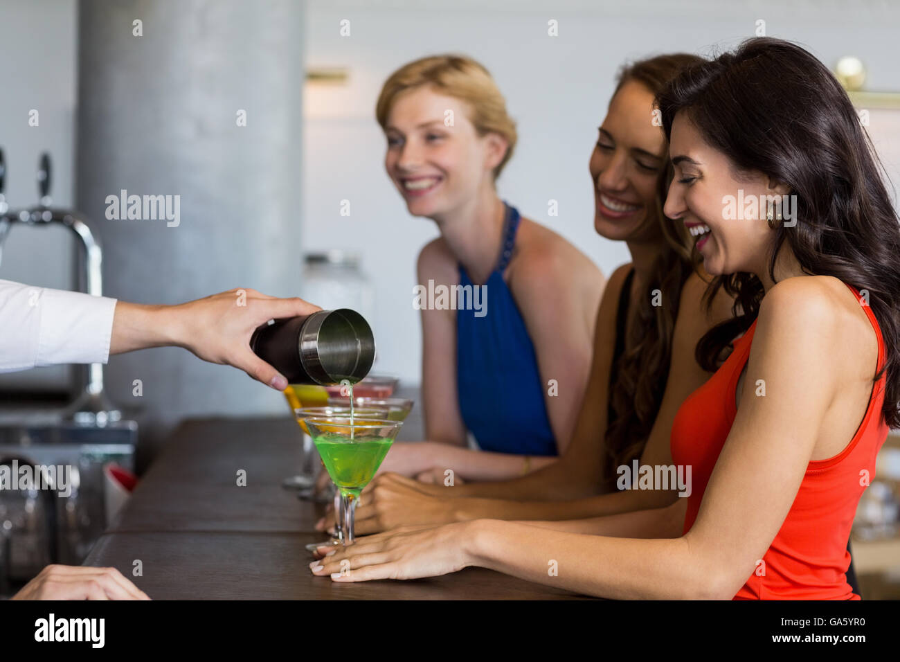 Waiter pouring cocktail into cocktail glass Stock Photo