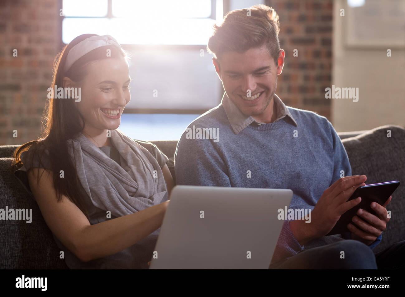 Smiling colleagues working while sitting in office Stock Photo