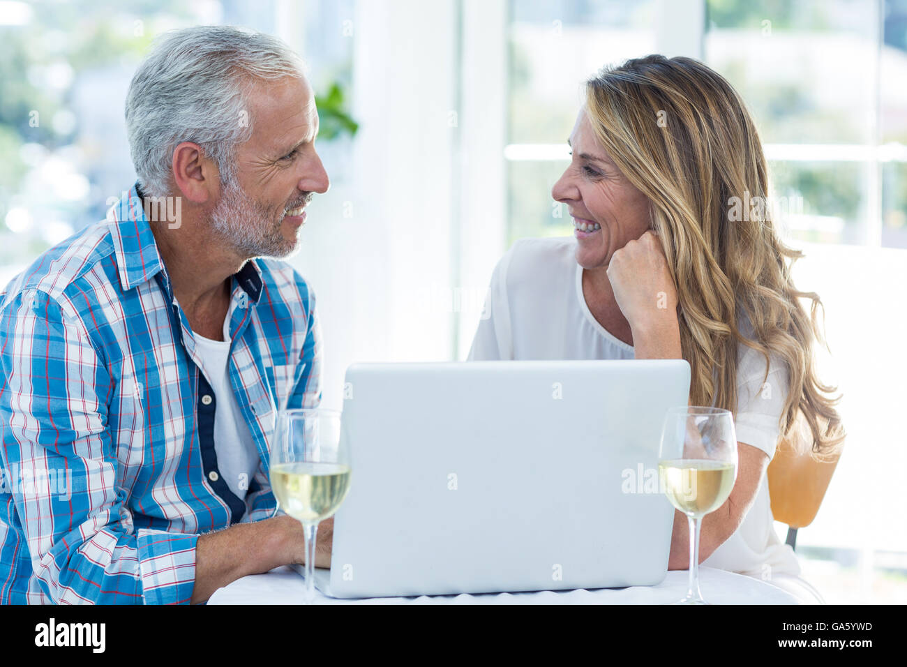 Mature couple talking while sitting by table Stock Photo