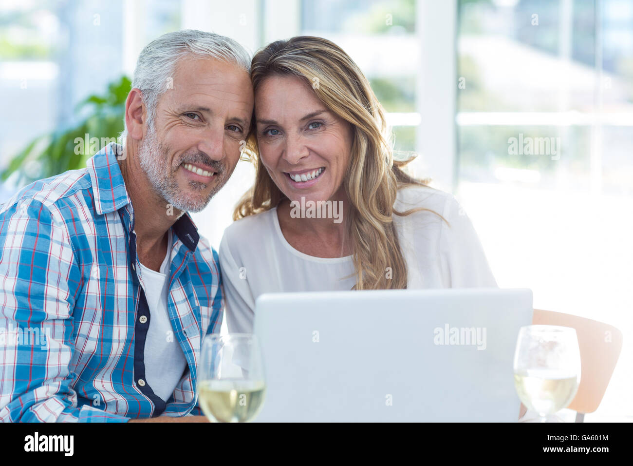 Mature couple sitting by table in restaurant Stock Photo