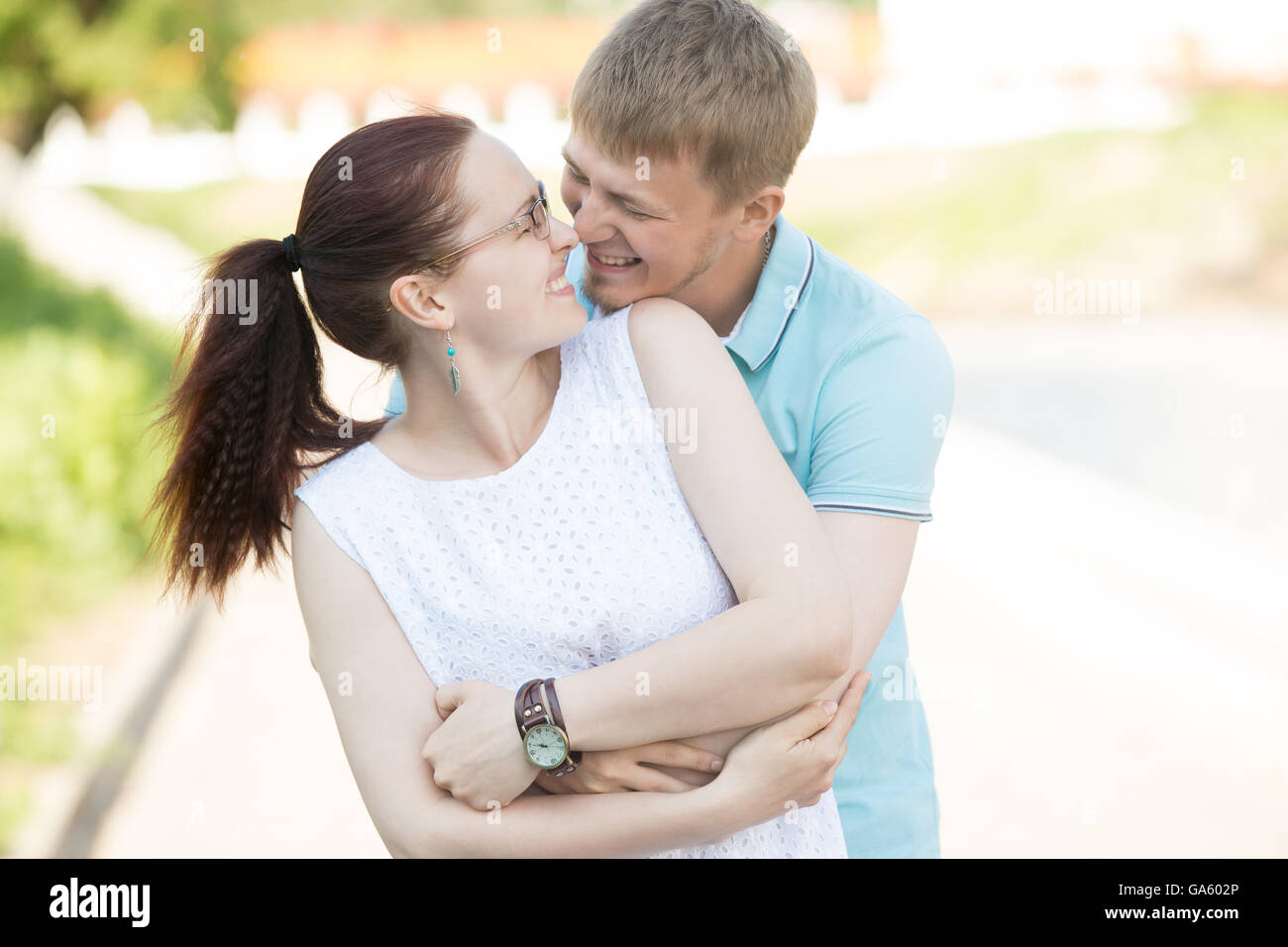 Beautiful young couple hugging each other tightly laughing and ...