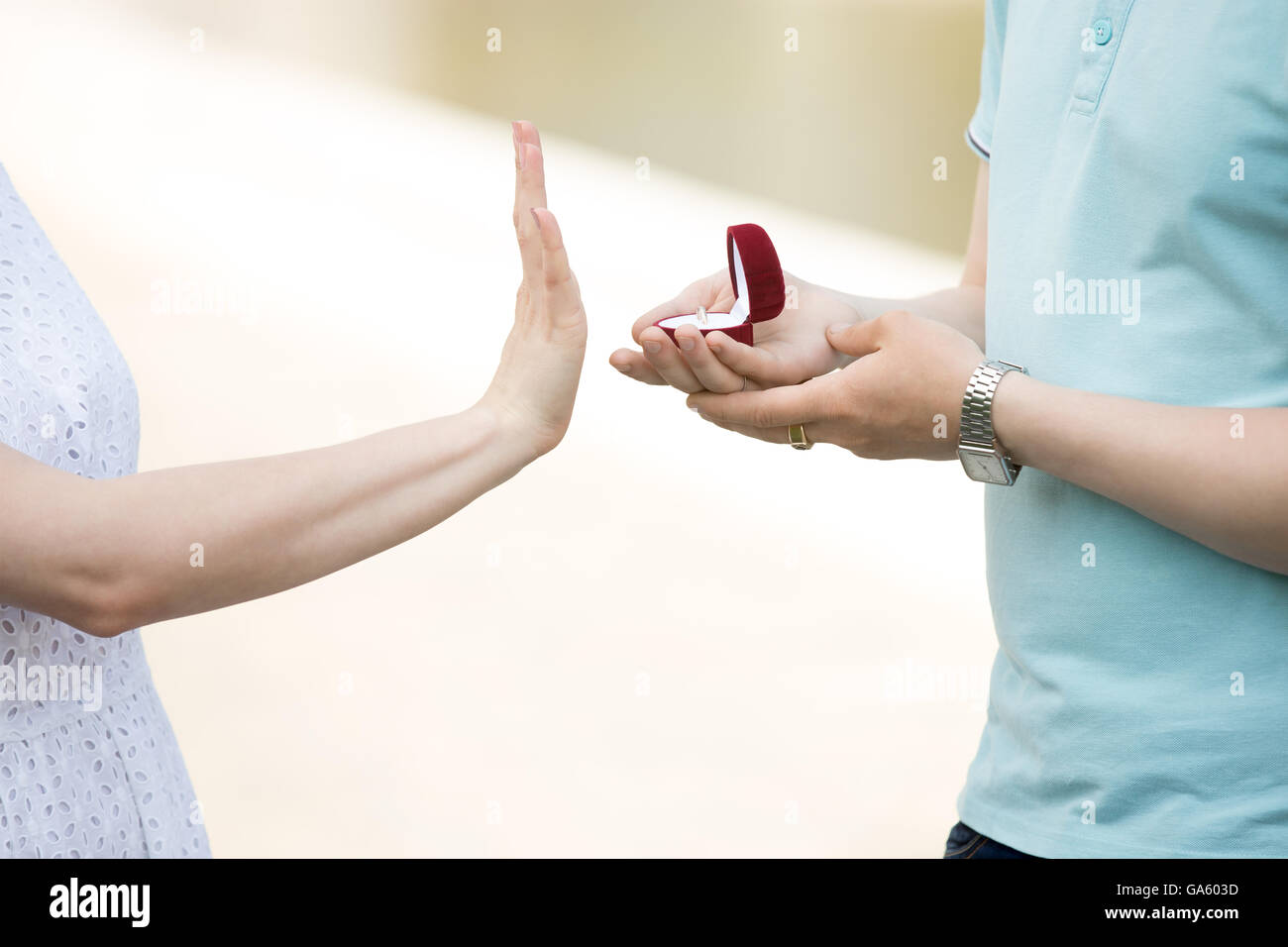 Close-up of hand of young woman turning down engagement proposal. Handsome man holding red box with engagement ring Stock Photo
