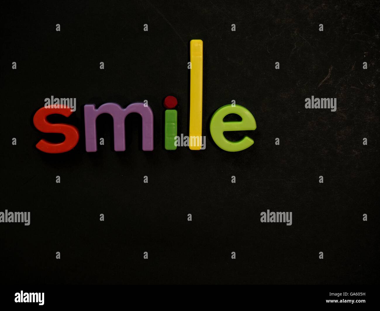 Smile! Inspirational message in vibrant colorful magnet letters Stock Photo