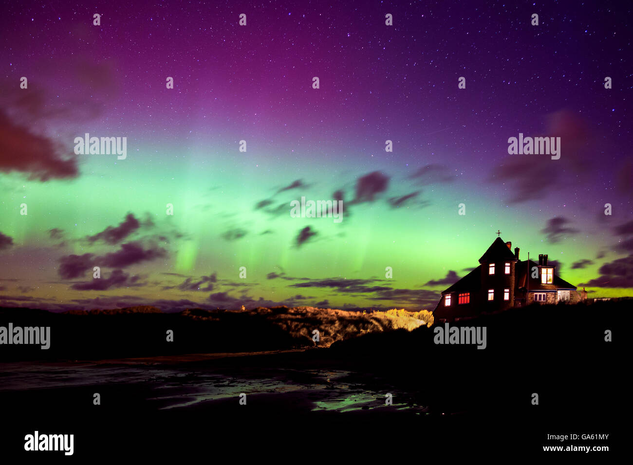 The Aurora Borealis lights up the night sky over Beadnell Bay in Northumberland Stock Photo