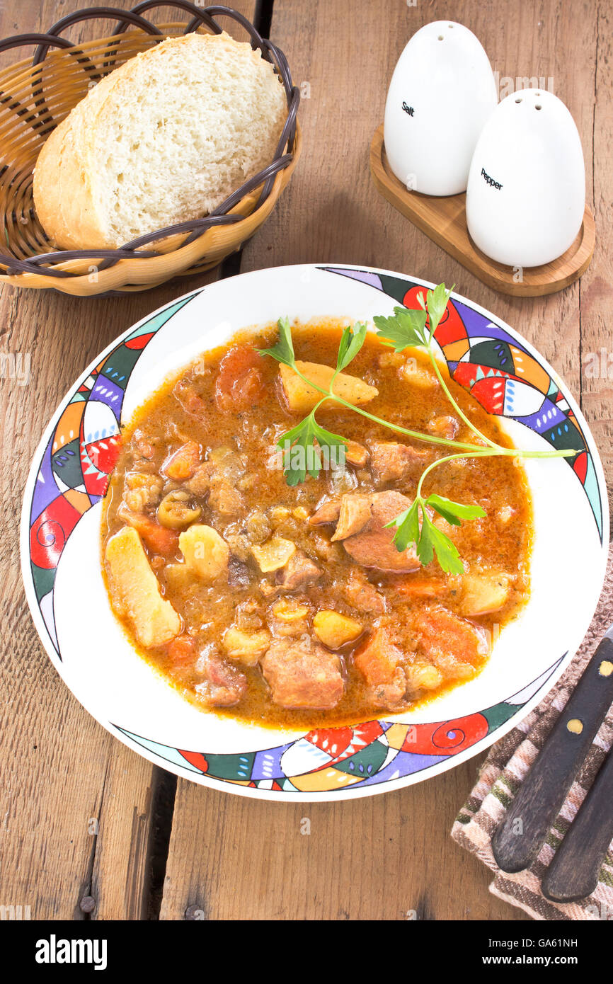 Pork stew in plate on wooden table Stock Photo
