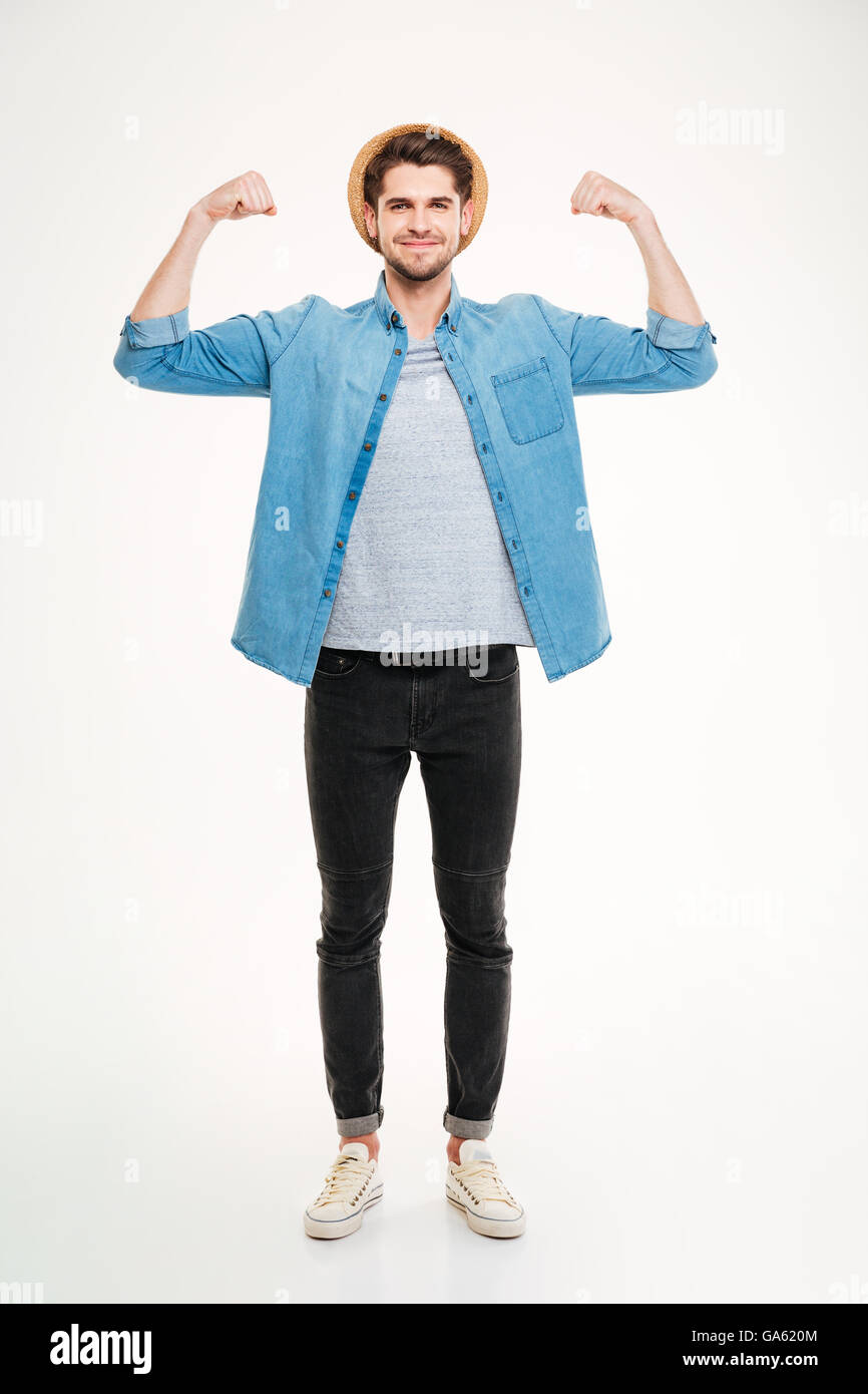 Full length of happy handsome young man standing and showing biceps over white background Stock Photo