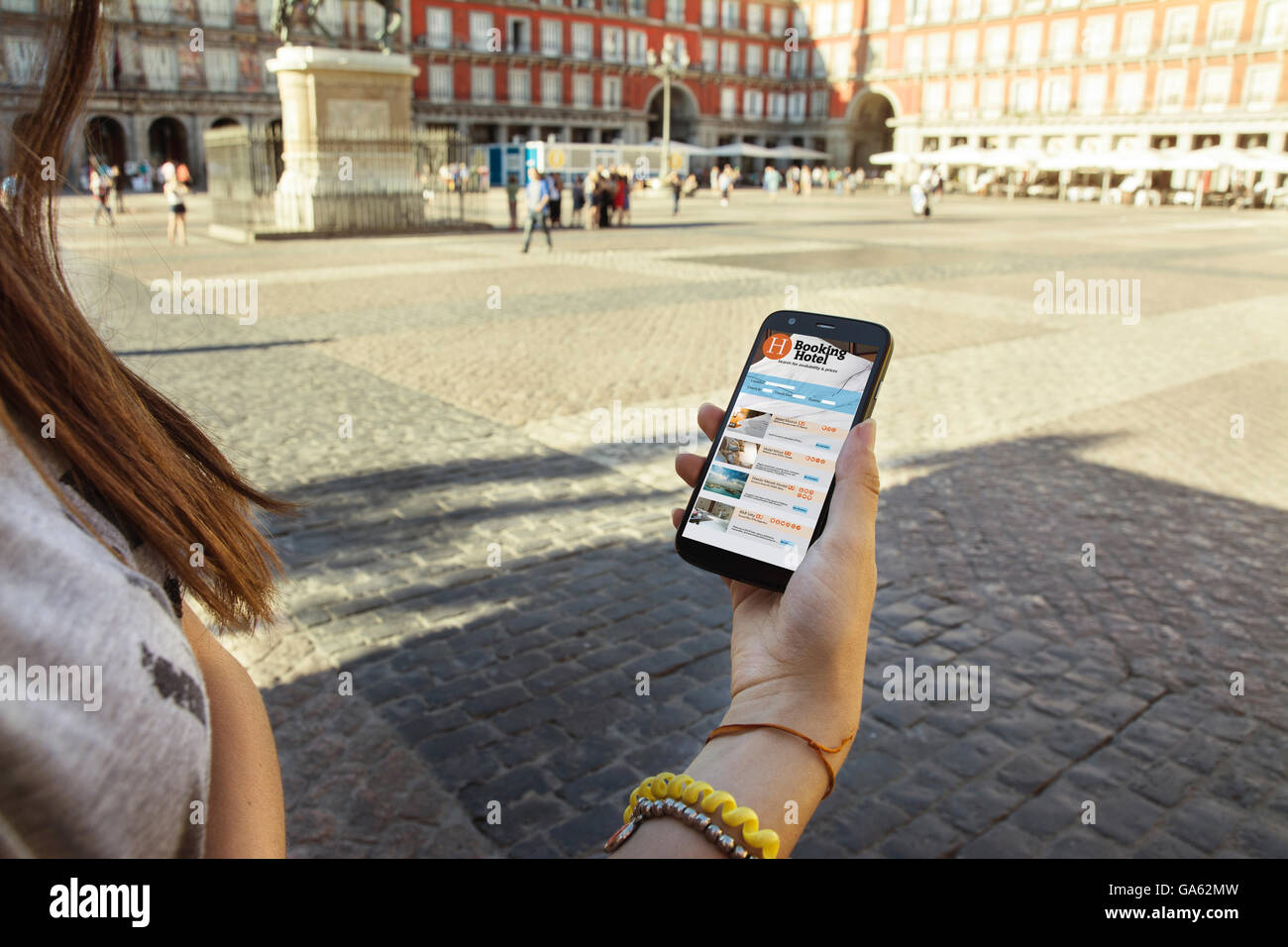 Teen girl with mobile phone in hand, tourist city of madrid background Stock Photo