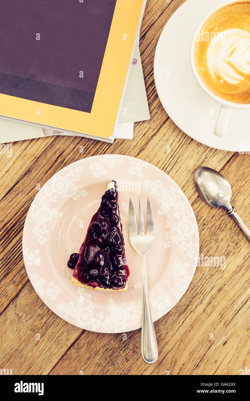 Hot coffee latte with blue berry cheese cake leisure lifestyle on wooden table Stock Photo