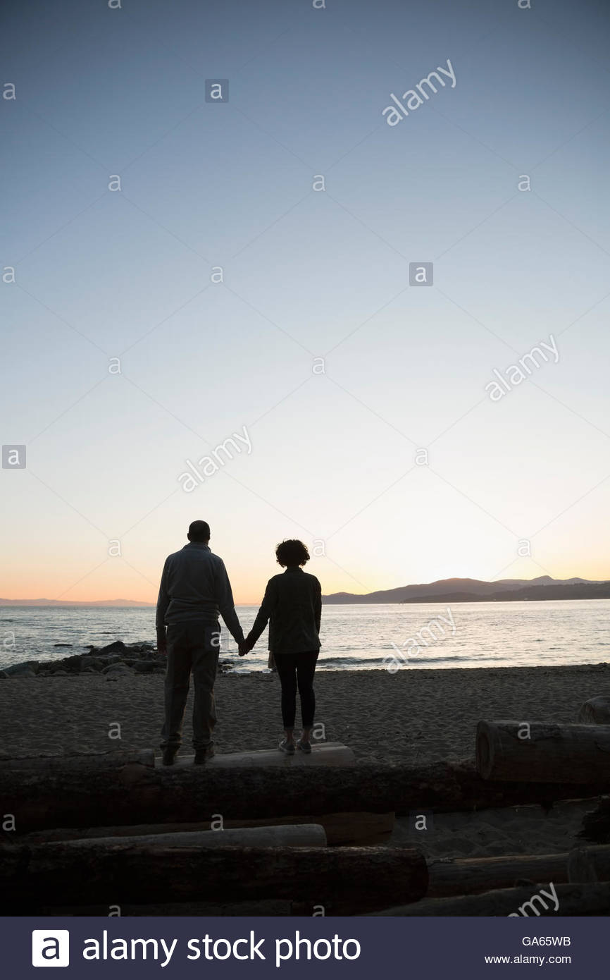 Couple holding hands on beach sunset hi-res stock photography and ...