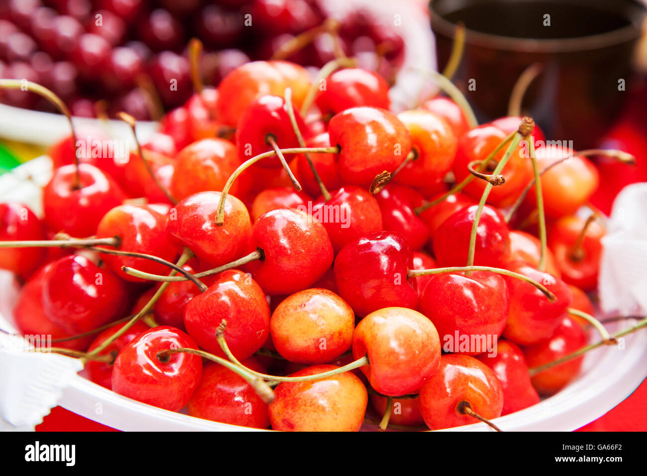 dish with a fresh ripe cherry on the table closeup Stock Photo