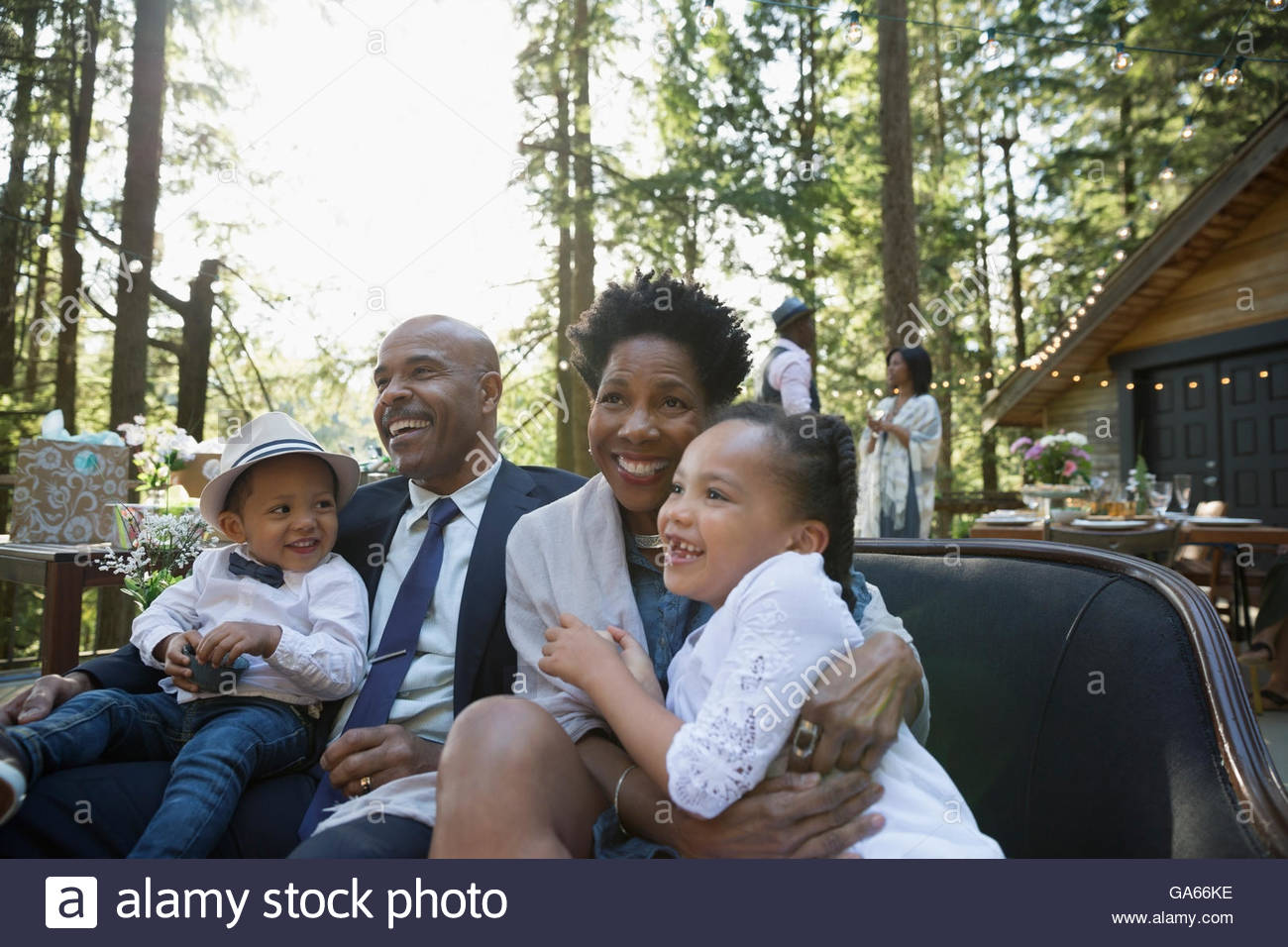 Smiling grandparents with grandchildren at party on balcony in woods Stock Photo