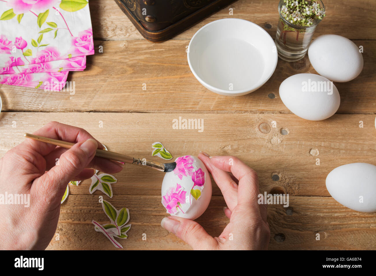 Apply woman PVA glue on colored Easter egg, with the technique of