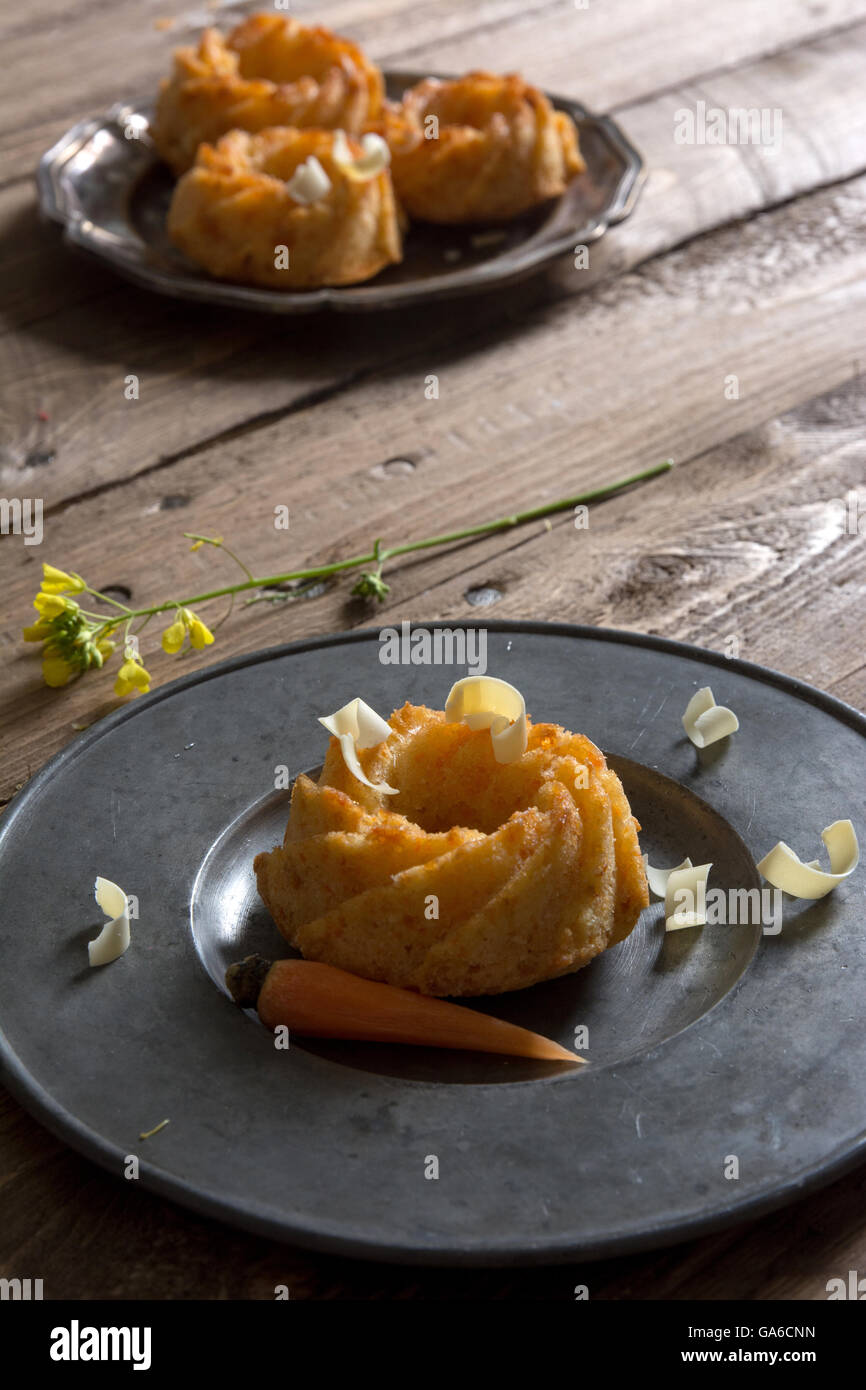 mini carrot cake with white chocolate on a rustic wooden table. Stock Photo