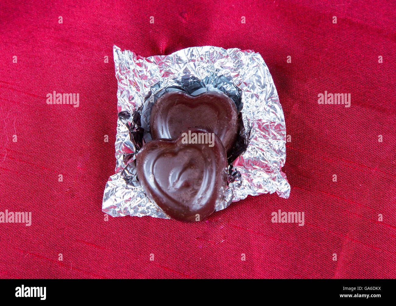 Heart shaped valentine's day chocolate candies on a red background. Stock Photo