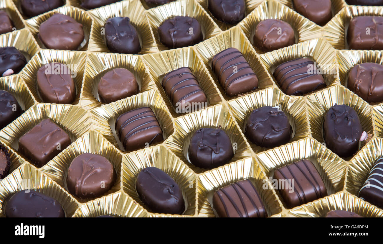 Various chocolates in a box with gold foil Stock Photo Alamy