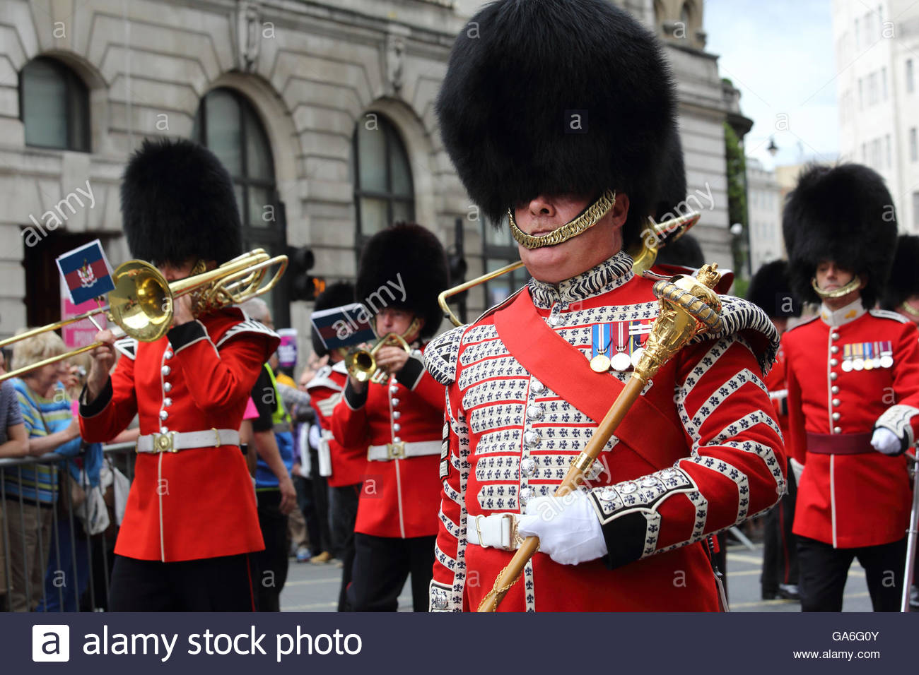 Marching guardsmen in red uniforms take part in London pride Stock Photo
