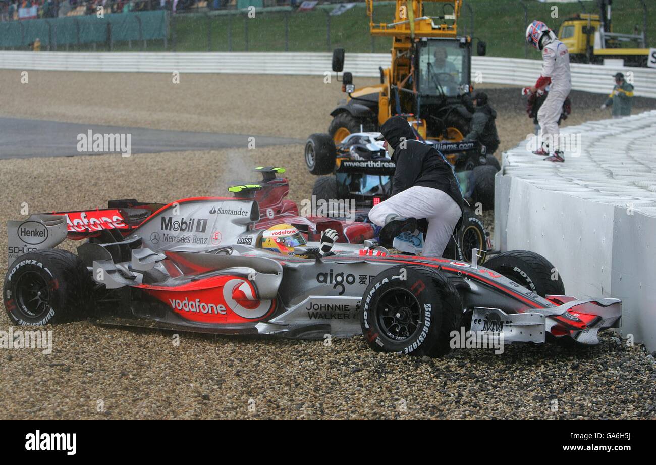 McLaren Mercedes' Lewis Hamilton keeps his engine running after crashing off in the rain, he is lifted back onto the circuit and will continue the race Stock Photo