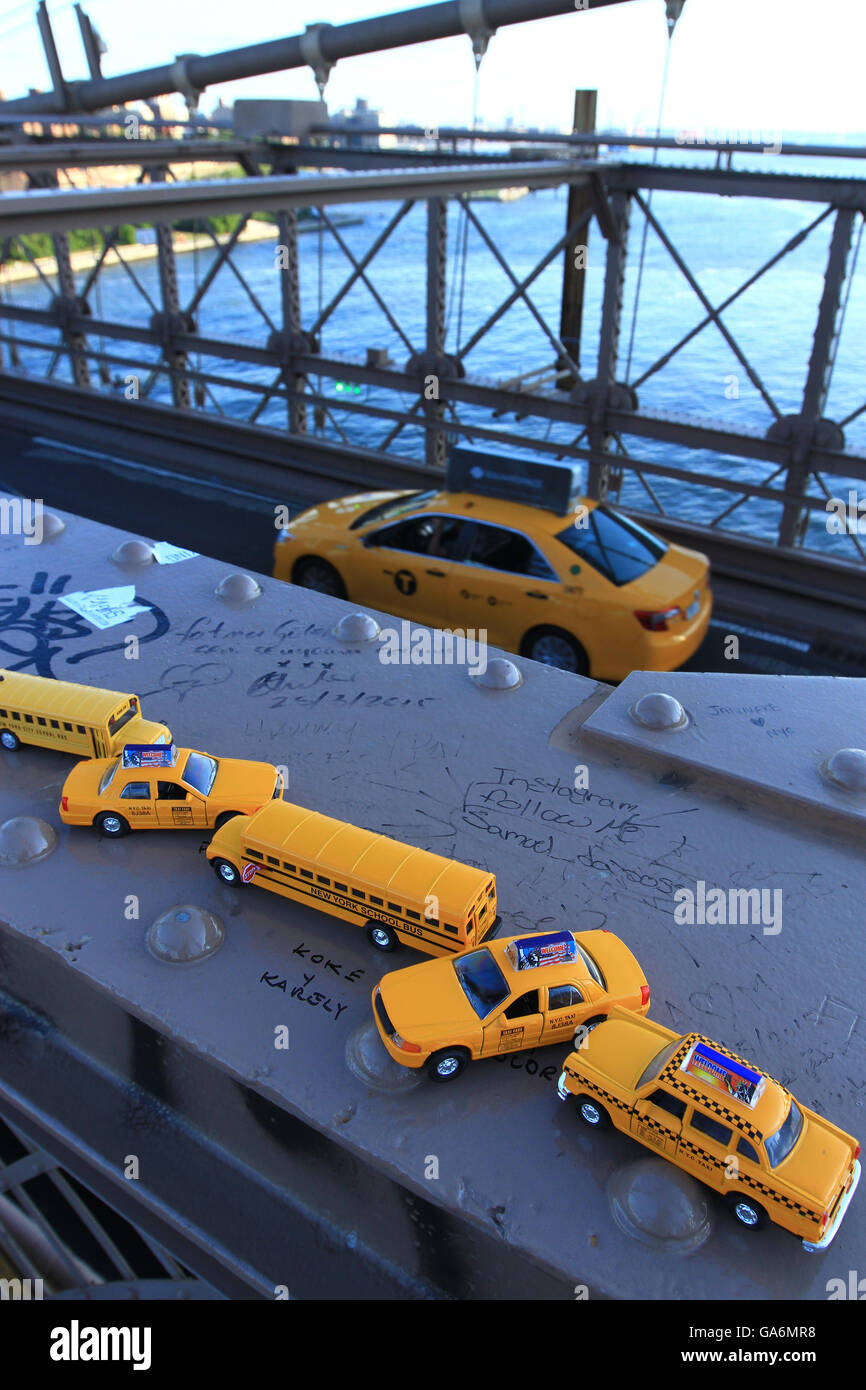 Yellow taxi drives across the landmark Brooklyn Bridge in New York